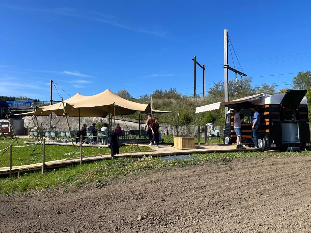 Photo du terrain de chasse au trésor de Terra Trésor. On y voit le stand de nourriture, une tonnelle, et des WC au loin.